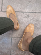 Woven huaraches worn on a stone pavement